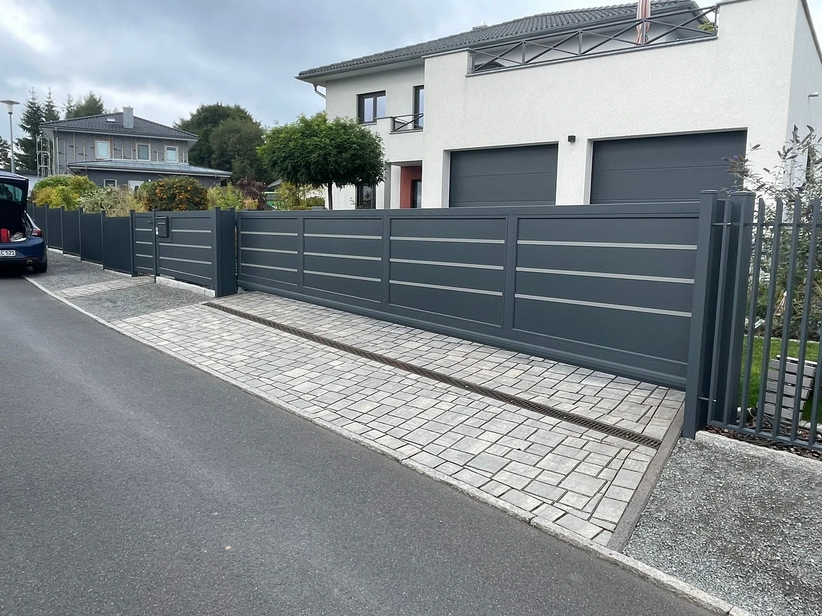 Zaunanlage Foglio in Anthrazit mit glatter Blechfüllung und silbernen Zierbändern