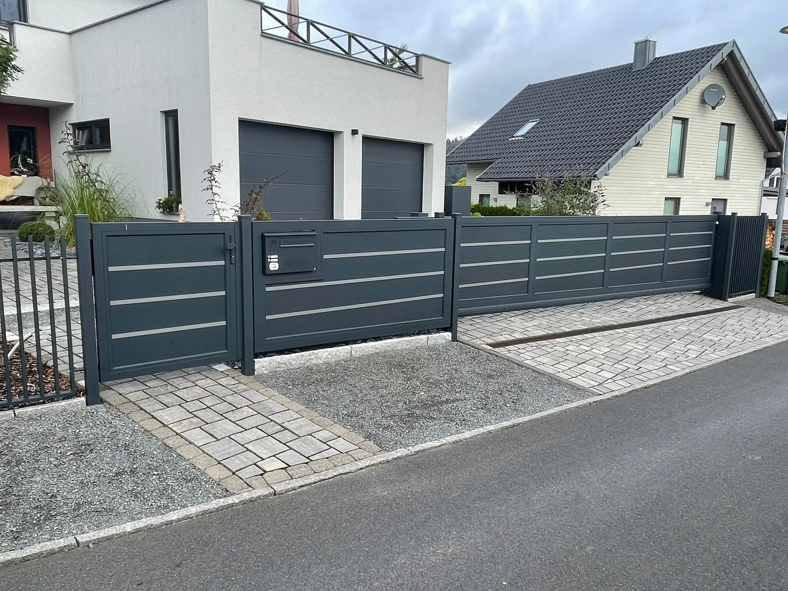 Foglio als Hofeinfahrt mit Gehtür, Schiebetor und passender Zaunanlage in Anthrazit